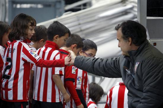 El DT del Athletic de Bilbao, el argentino Marcelo Bielsa (d), saluda a una niña momentos antes del comienzo del partido ante la Real Sociedad. Foto: EFE