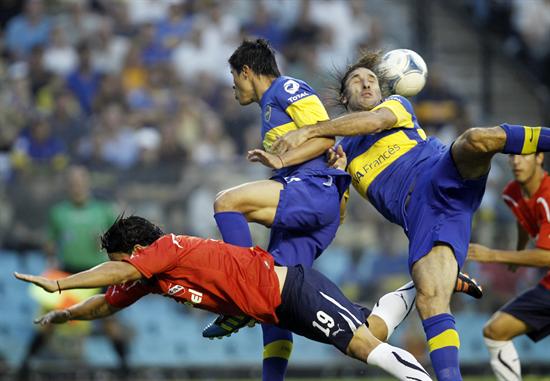 El jugador de Independiente Ernesto Farías (i) lucha por el balón entre Facundo Roncaglia (c) y Rolando Schiavi de Boca. Foto: EFE