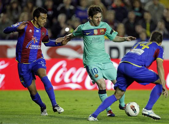 El delantero argentino del FC Barcelona Lionel Messi (c) conduce el balón ante los jugadores del Levante UD. Foto: EFE