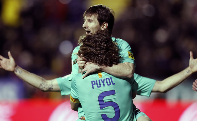 El delantero argentino del FC Barcelona Lionel Messi (arriba) celebra su primer gol junto a su compañero Carles Puyol ante Levante. Foto: EFE