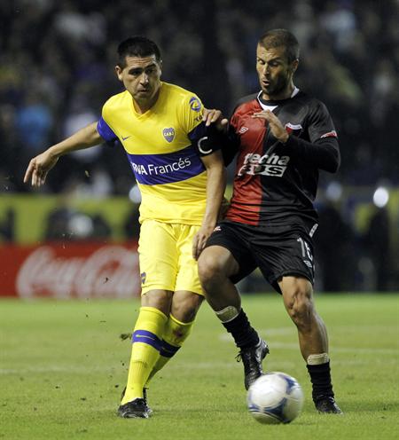 El jugador de Boca Juniors Juan Román Riquelme (i) disputa el balón con Gabriel Graciani (d) de Colón de Santa Fé. Foto: EFE