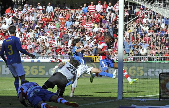 El delantero nigeriano del Granada, Odion Ighalo (d), bate al portero del RCD Espanyol, el argentino Cristian Alvarez (c). Foto: EFE