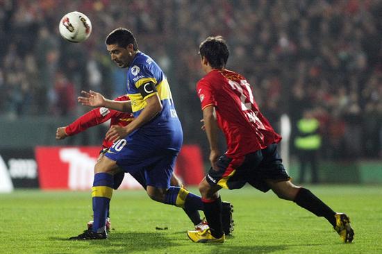 El jugador de Boca Juniors Juan Román Riquelme (c) cabecea el balón ante la marca de Mauro Díaz (d), de Unión Española. Foto: EFE