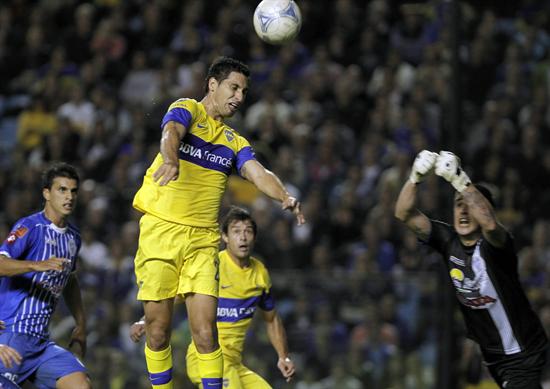 El jugador de Boca Juniors Juan Insaurralde (2-i) cabecea y convierte el primer gol de su equipo ante el portero de Godoy Cruz Nelson Ibáñez. Foto: EFE