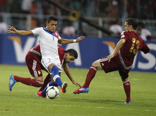 El jugador chileno Alexis Sánchez (c) es marcado por el venezolano Luis Manuel Seijas. Foto: EFE