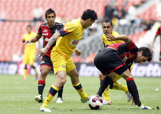 El centrocampista Rubens Sambueza (i) de América disputa un balón con Facundo Erpen de Atlas. Foto: EFE