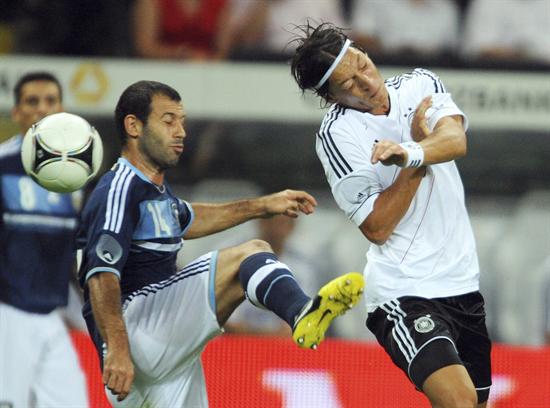 El alemán Mesut Özil (d) lucha por el control del balón con el argentino Javier Mascherano. Foto: EFE