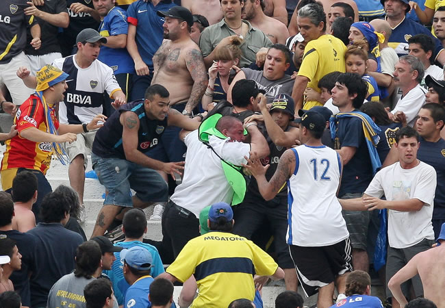 Aficionados de Boca Juniors agreden a guardias de seguridad durante el partido entre Boca y River. Foto: EFE