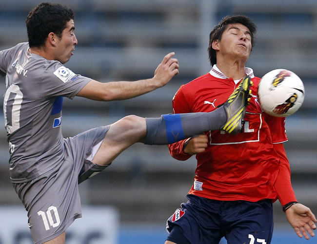 El jugador de la Universidad Católica de Chile Fernando Cordero (i) disputa el balón con Samuel Cáceres (d) de Independiente. Foto: EFE