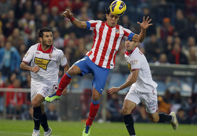 El delantero colombiano del Atlético de Madrid Radamel Falcao (c) cabecea el balón contra Sevilla. Foto: EFE