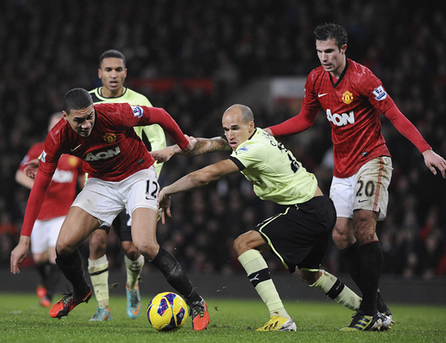 El jugador del Manchester United, Chris Smalling (i), lucha por el balón con Gabriel Obertan (c), del Newcastle United. Foto: EFE