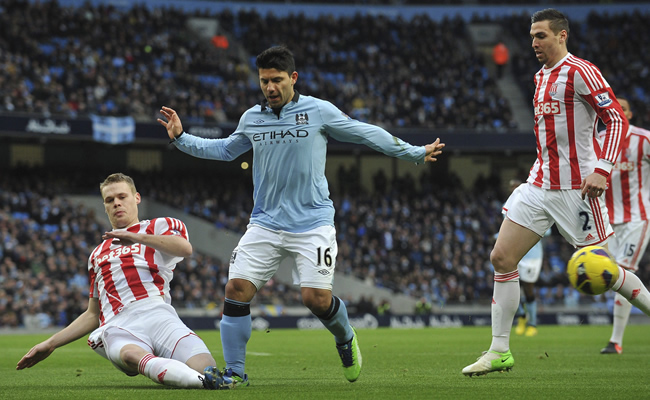 El delantero argentino del Manchester City, Sergio Kun Agüero (c), lucha por el balón con Ryan Shawcross, del Stoke City. Foto: EFE