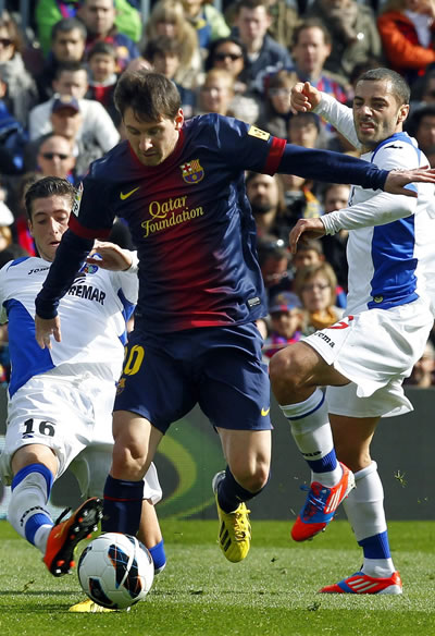 El delantero argentino del F.C.Barcelona, Lionel Messi (i), intenta controlar el balón ante los jugadores del Getafe. Foto: EFE