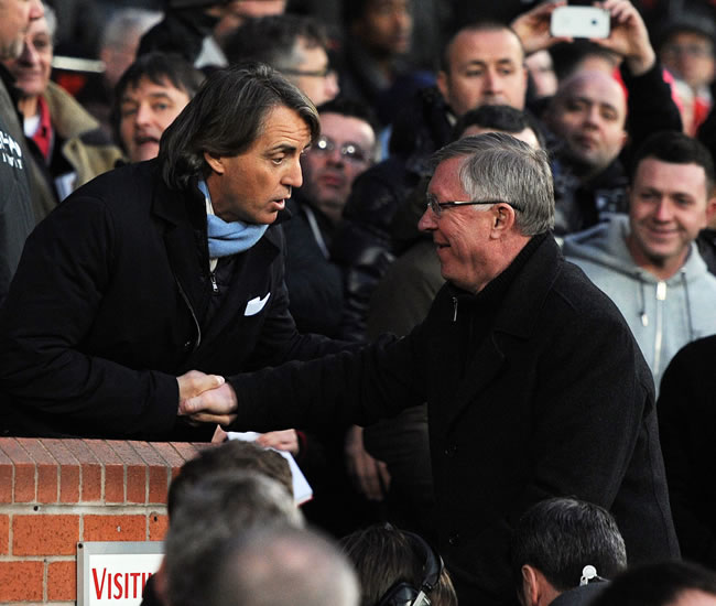 El director técnico del Manchester United, sir Alex Ferguson (d) estrecha la mano de su par de Manchester City, Roberto Mancini. Foto: EFE