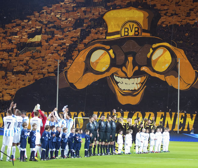 Los jugadores del Málaga (izda) y los del Borussia Dortmund (dcha) saludan antes de comenzar el partido. Foto: EFE