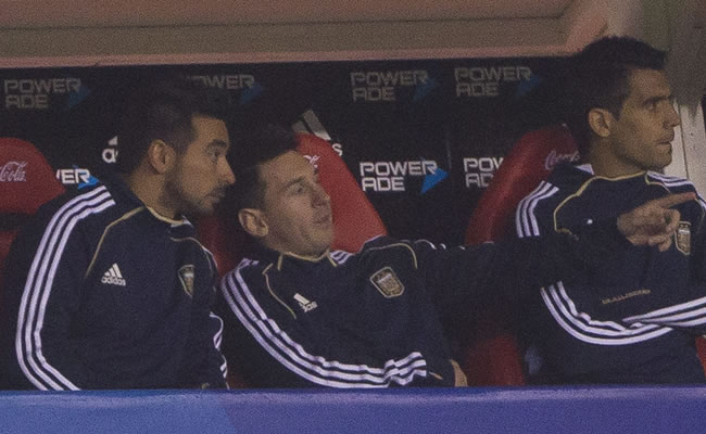 Los jugadores argentinos Ezequiel Lavezzi (i) y Lionel Messi (c) observan desde el banco las acciones ante Colombia. Foto: EFE