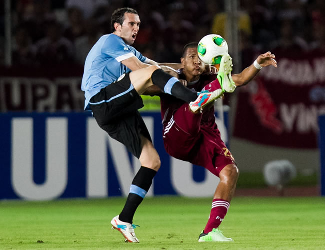 El jugador de la selección de Uruguay Diego Perez (i) disputa el balón contra José Rondón de Venezuela. Foto: EFE