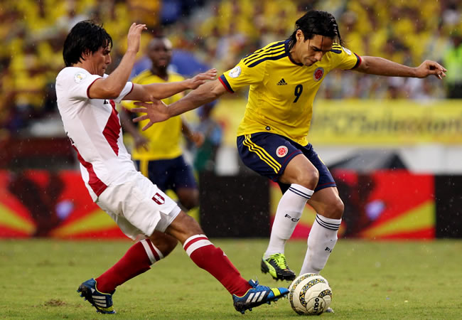 El jugador colombiano Radamel Falcao García (d) disputa el balón con el peruano Edwin Retamoso (i). Foto: EFE