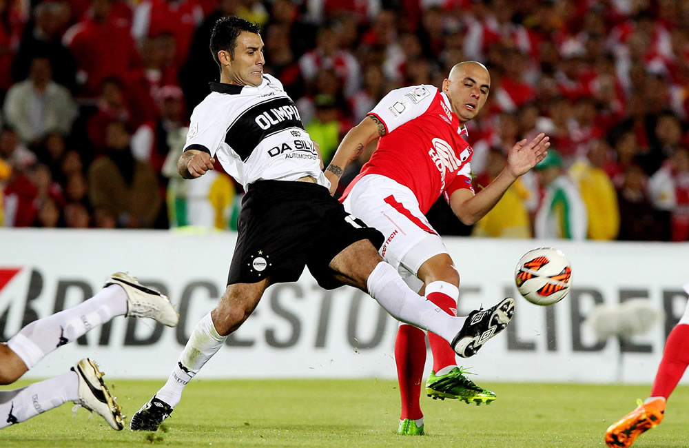 El jugador de Santa Fe Omar Pérez (d) disputa un balón con Nelson Fabián Benítez (d) del Olimpia de Paraguay. Foto: EFE