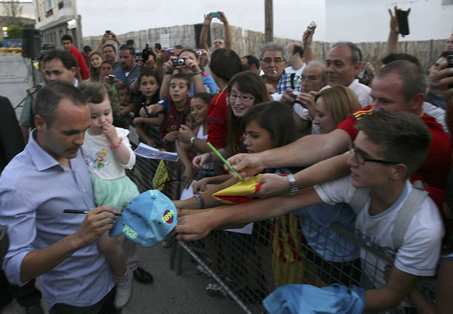 El futbolista albaceteño del FC Barcelona Andrés Iniesta (i) firma autógrafos durante el homenaje por parte de las peñas barcelonistas de Castilla-La Mancha. Foto: EFE