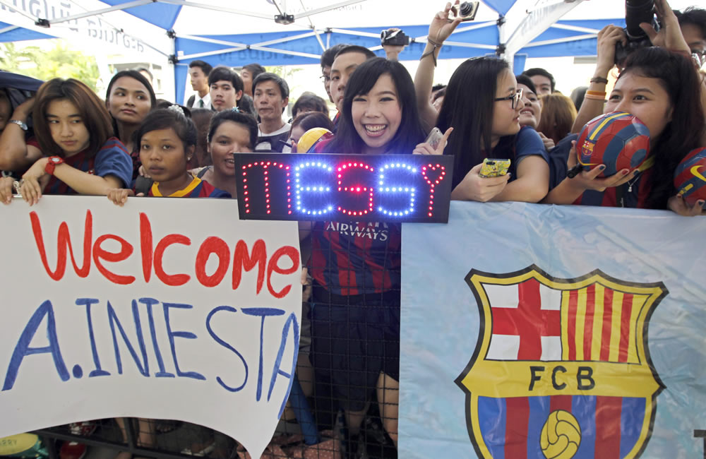 Aficionados tailandeses reciben a Lionel Messi y Andres Iniesta. Foto: EFE
