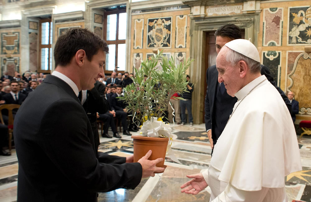 Papa Francisco (d) recibiendo un árbol de olivo de manos del jugador de la selección argentina de fútbol, Lionel Messi (i), durante una audiencia en el Vaticano. Foto: EFE
