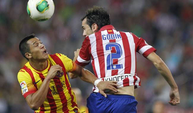 El defensa uruguayo del Atlético de Madrid Godín (d) salta a por un balón con el chileno Alexis Sánchez, del FC Barcelona. Foto: EFE