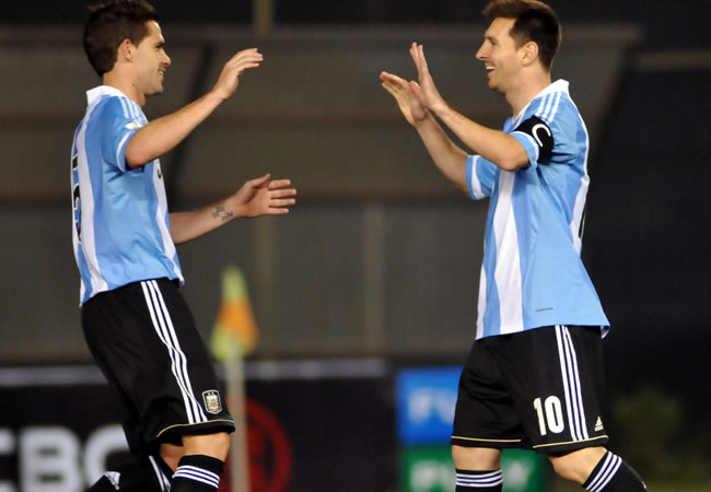 Leo Messi (d) de Argentina celebra un gol ante Paraguay con Fernando Gago (i). Foto: EFE