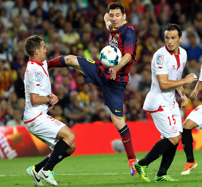 El delantero argentino del FC Barcelona Leo Messi (c) pelea un balón con Fernando Navarro (i) y Trochowski, ambos del Sevilla. Foto: EFE