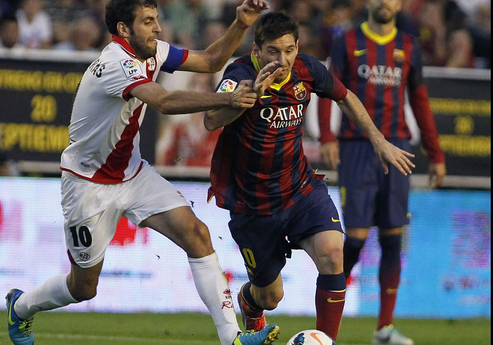 El argentino del FC Barcelona el delantero Leo Messi se lleva el balón ante el acoso del jugador del Rayo Vallecano Roberto Transhorras. Foto: EFE