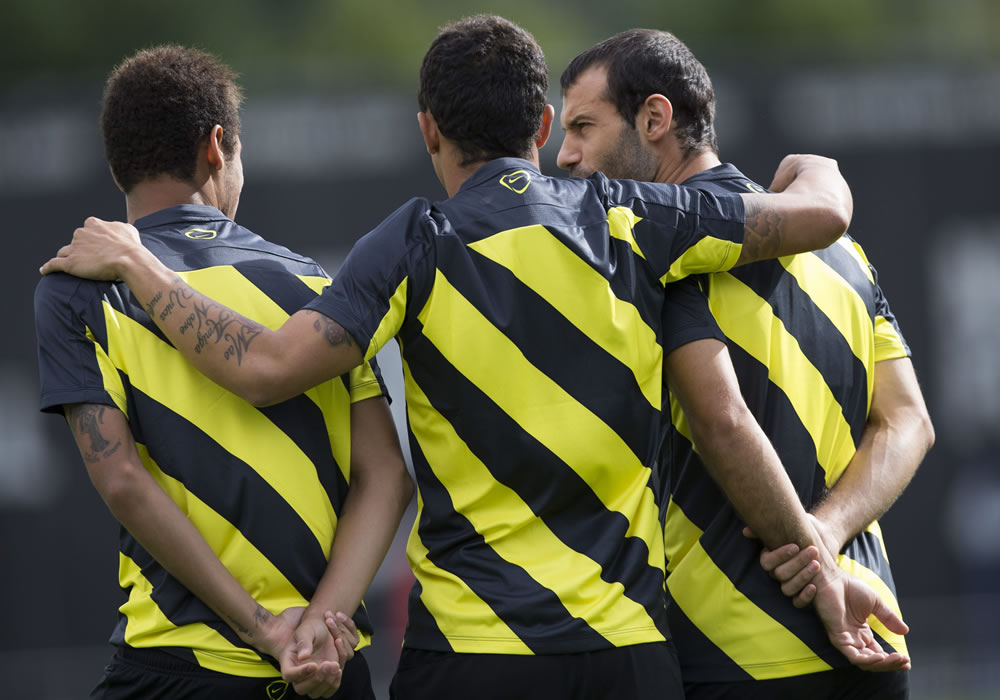 Adriano (c) abraza a Neymar (i) y Mascherano (d) durante el entrenamiento del Barça. Foto: EFE