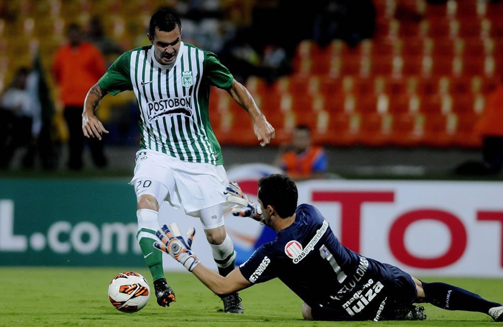 El jugador de Atlético Nacional de Colombia Alejandro Bernal (i) disputa el balón con el guardameta Marcelo Lomba (d) de Bahía de Brasil. Foto: EFE