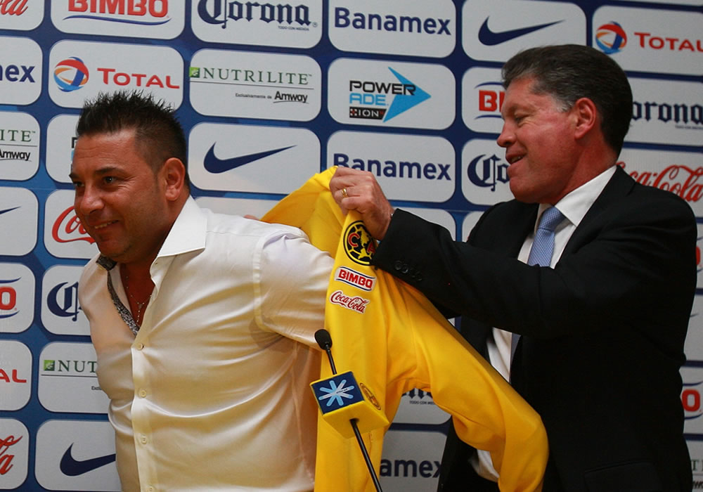 Ricardo Pelaez (d), director deportivo, le pone la camiseta del equipo Águilas del América al argentino Antonio Mohamed. Foto: EFE