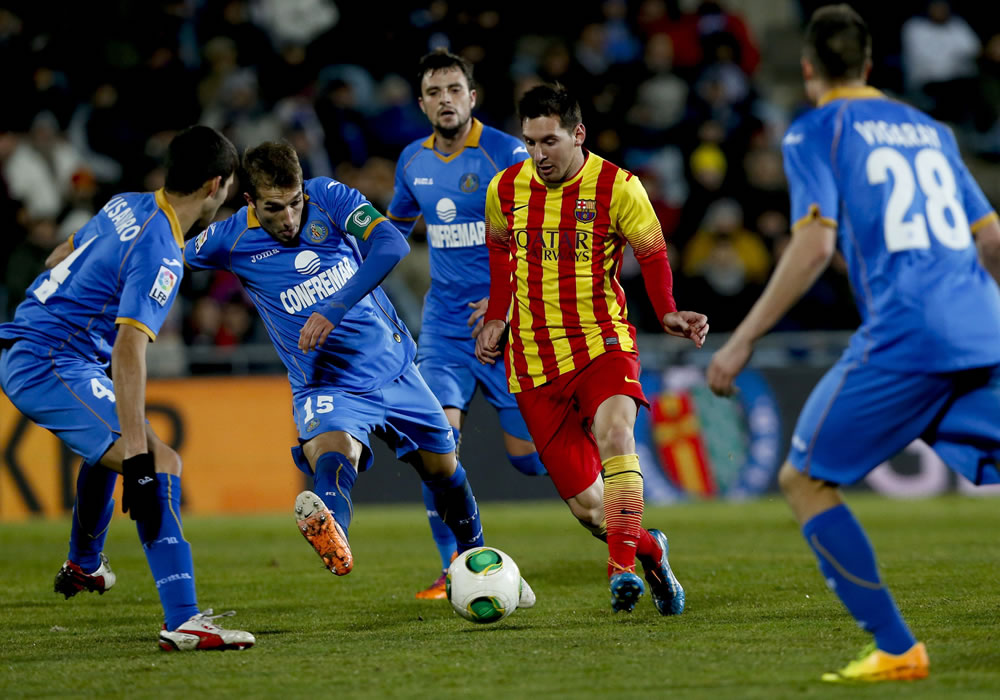 El delantero argentino del FC Barcelona Leo Messi (2d) controla el balón entre la defensa de los jugadores del Getafe. Foto: EFE