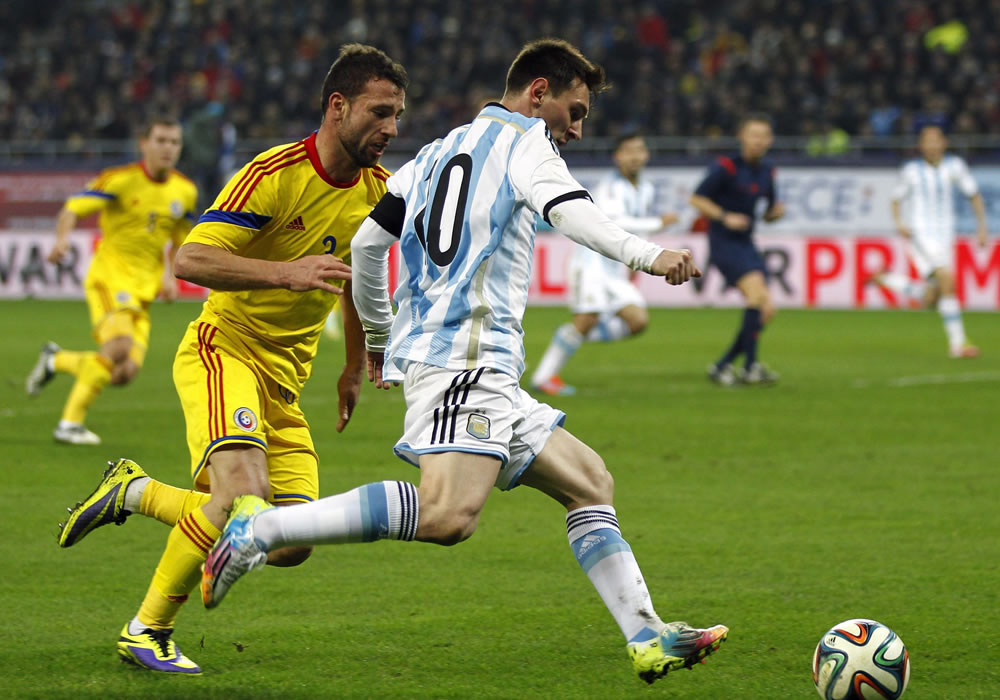 El delantero de la selección argentina, Leo Messi (d) lucha por el balón con Razvan Rat (i) de Rumanía. Foto: EFE