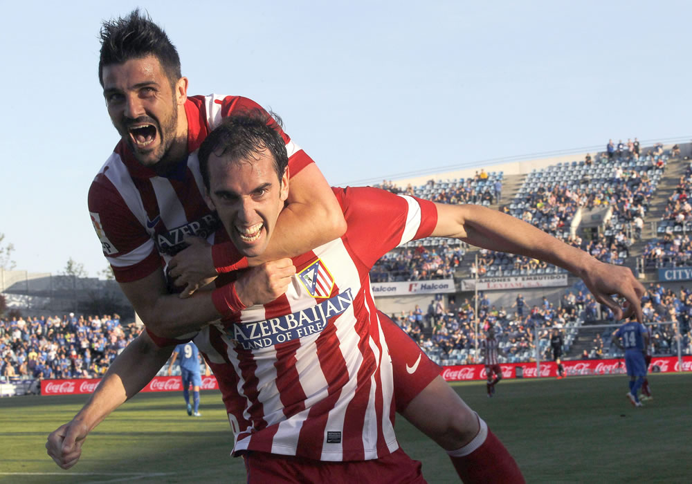 El defensa uruguayo del Atlético de Madrid Diego Godín (d) celebra con su compañero David Villa, la consecución del primer gol ante el Getafe-. Foto: EFE