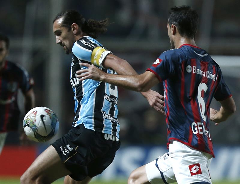 El jugador de San Lorenzo de Argentina, Santiago Gentiletti (d) disputa el balón con Hernán Barcos de Gremio. Foto: EFE