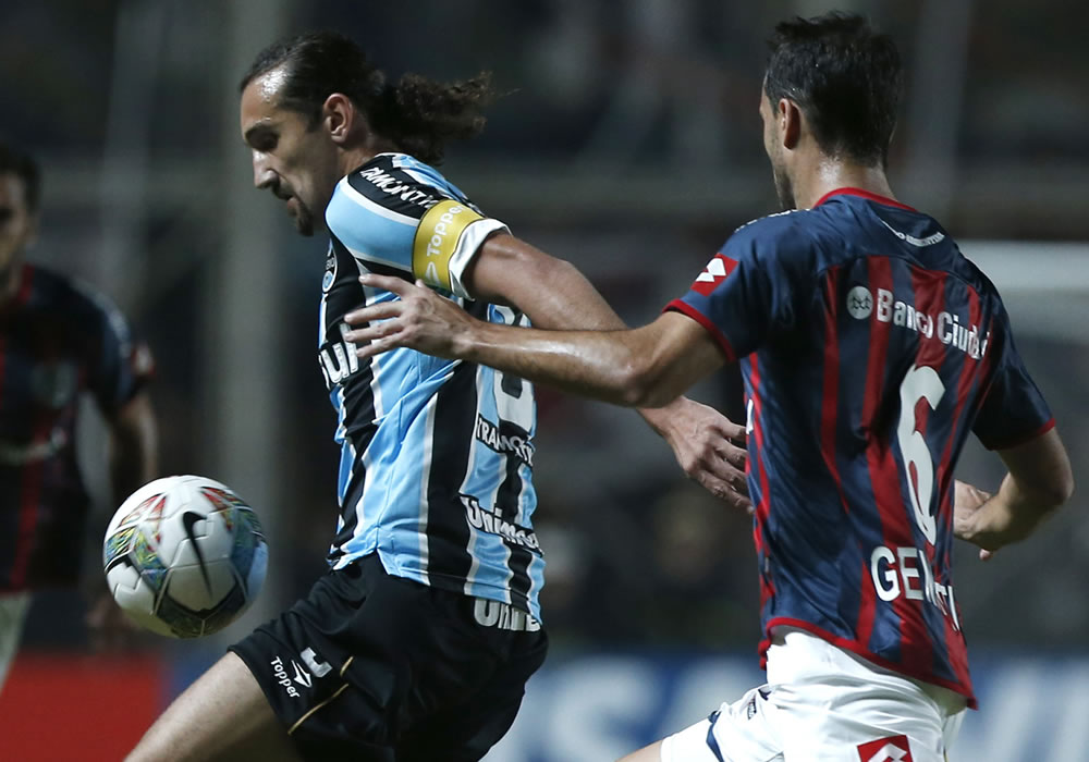 El jugador de San Lorenzo de Argentina, Santiago Gentiletti (d) disputa el balón con Hernán Barcos de Gremio de Brasil. Foto: EFE