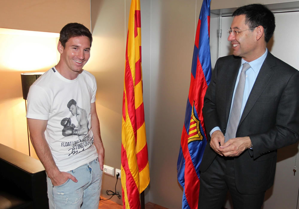Fotografía cedida por el FC Barcelona de Leo Messi (i) y del presidente del club Josep Maria Bartomeu (d), en la renovación del delantero, antes de viajar a Argentina. Foto: EFE