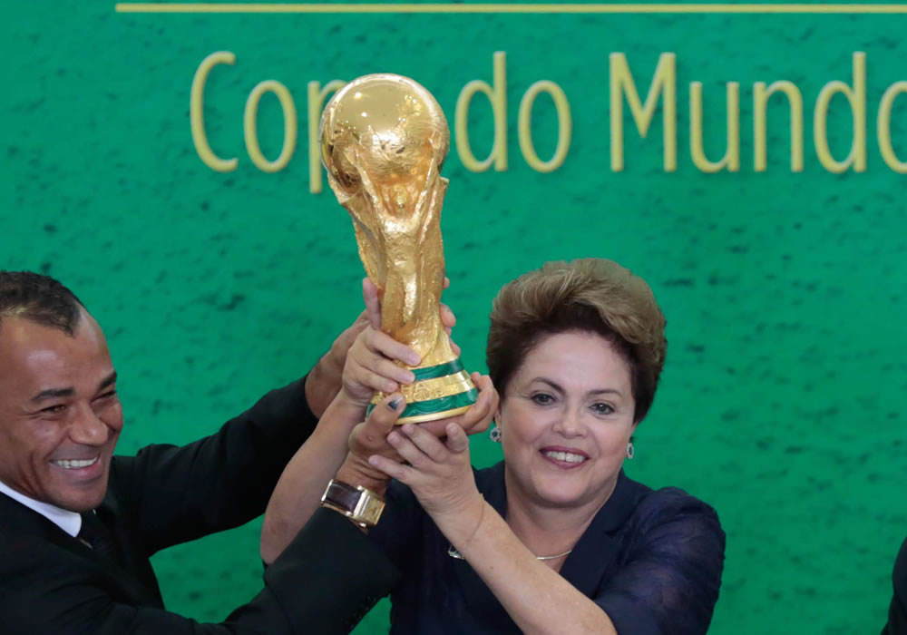 La presidenta de Brasil, Dilma Rousseff (d), y el exjugador brasileño Cafú (i), sostienen el trofeo de la Copa del Mundo. Foto: EFE