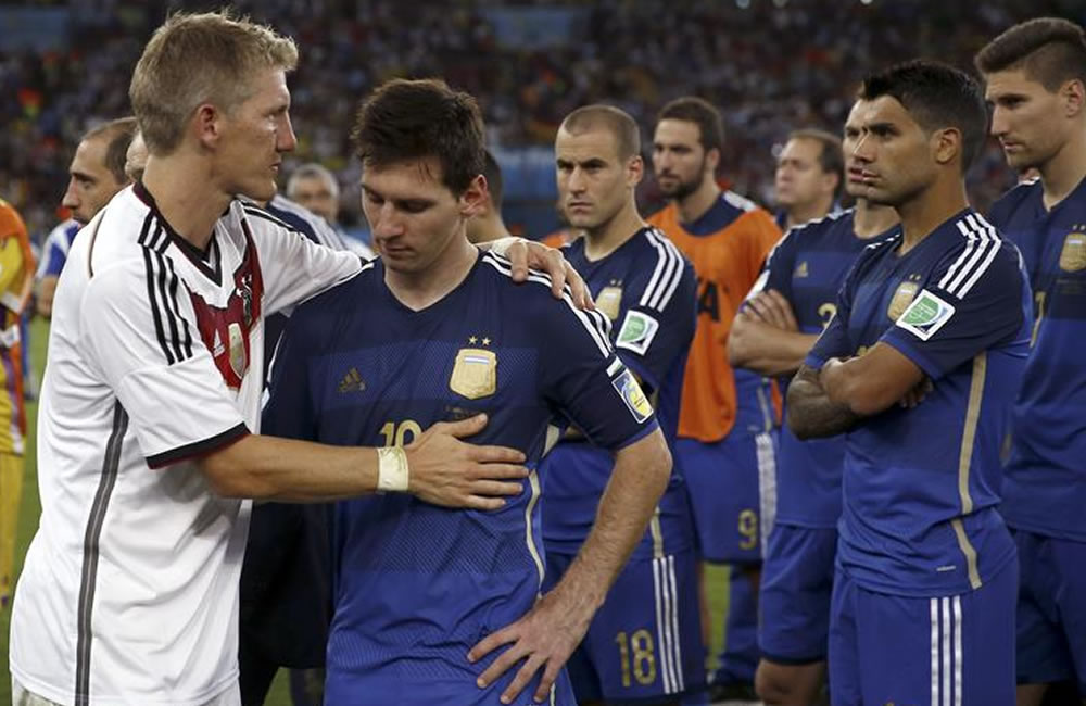 El centrocampista alemán Bastian Schweinsteiger (i) consuela al delantero argentino Lionel Messi. Foto: EFE