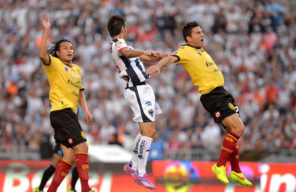 Cesar Delgado (c) de Monterrey disputa el balón con Leandro Cufre (d). Foto: EFE