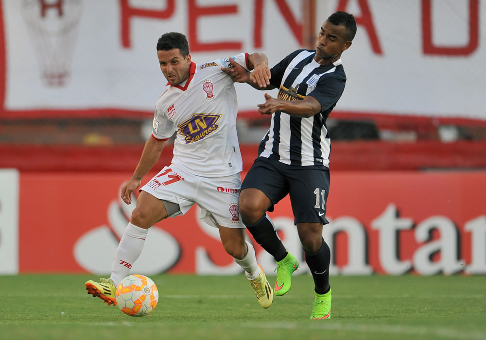 El jugador de Alianza Lima Luis Trujillo (d) disputa el balón con Agustin Torassa (i) de Huracán de Argentina. Foto: EFE