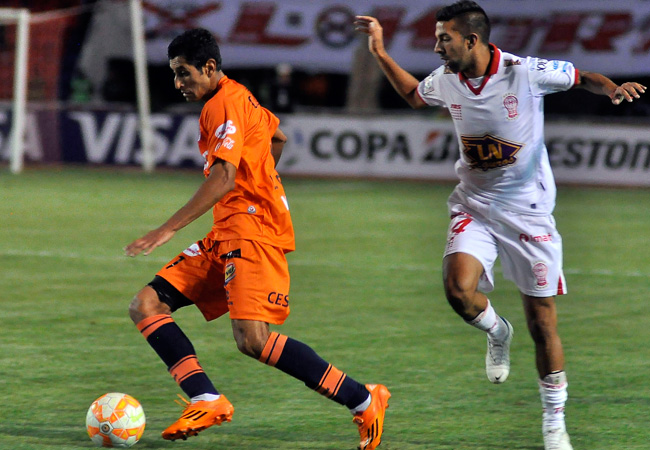 El jugador de Universitario de Bolivia, Leonardo Castro (i) disputa el balón con Ezequiel Gallegos de Huracán de Argentina. Foto: EFE