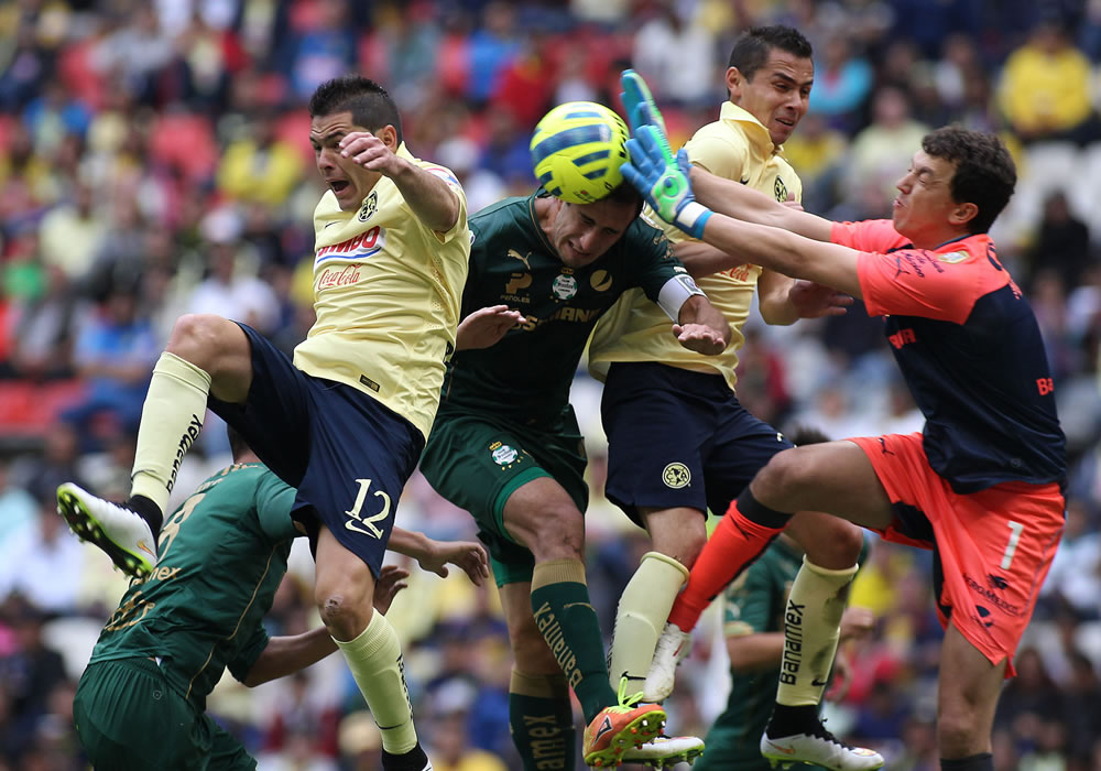 El jugador de América Pablo Aguilar (i) disputa el balón con el guardameta Agustín Marchesin (d) de Santos. Foto: EFE