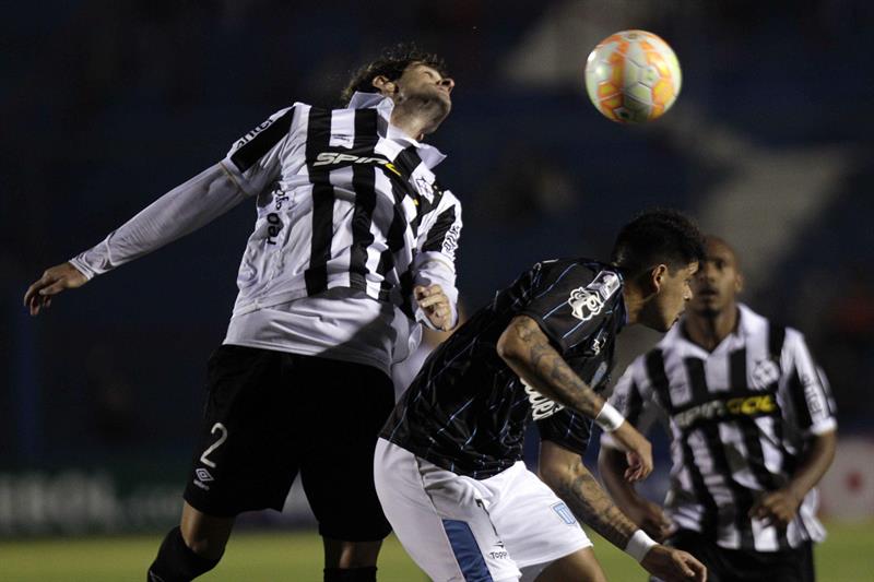 Gastón Bueno (i) del Wanderers disputa el balón con Gustavo Bou (d) del Racing Club. Foto: EFE