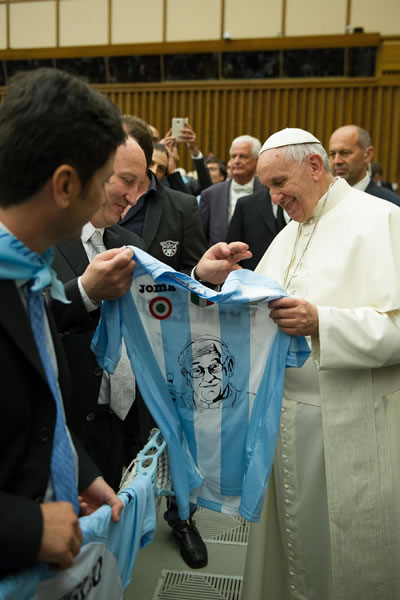 El papa Francisco (dcha) mientras sostiene una camiseta con los colores deEl club de fútbol Sociedad Deportiva Lazio. Foto: EFE