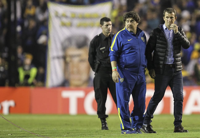 El entrenador de Boca Juniors, Rodolfo Arruabarrena (d), reacciona luego de que lanzaran gas pimienta desde la tribuna. Foto: EFE