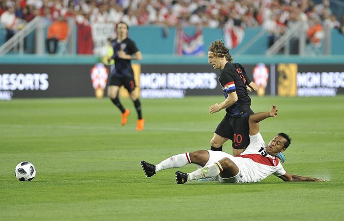 Luka Modric disputa un balón con Renato Tapia. (AFP). Foto: AFP